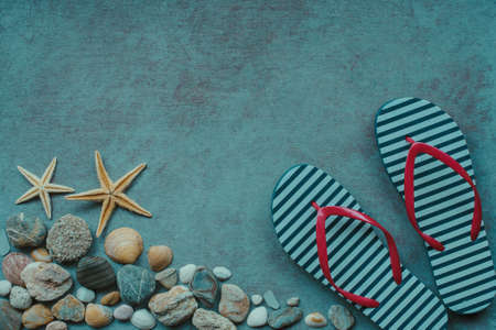 Beach background. Top view of beach seashells, flip flops, starfish, shells and sea pebbles on blue wooden background. Summer concept, Vintage retro styleの写真素材