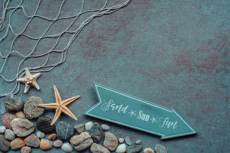 Beach background. Top view of beach seashells, starfish, shells and sea pebbles on blue wooden background. Summer concept, arrow with a slogan, Vintage retro styleの写真素材
