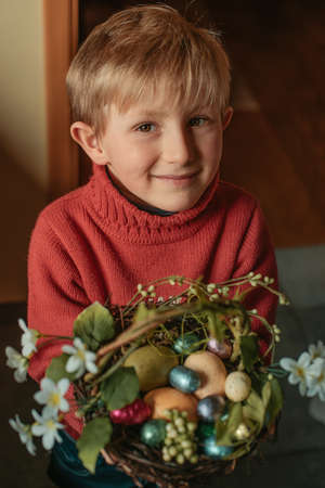 Happy Boy holding a basket with easter eggs