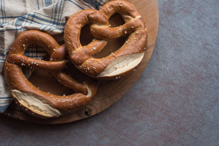Bretzel with salt on wooden background. Traditional pastry from Germany, pretzelの写真素材