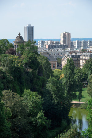 The Parc des Buttes Chaumont in northeastern Paris, France. Paris skyline in the backgroundのeditorial素材