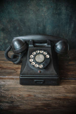 Vintage background with old telephone on wooden tableの写真素材