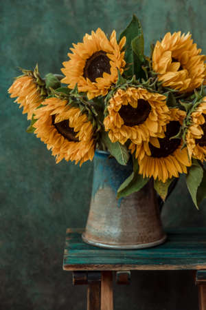 Beautiful sunflowers in the vase on the tableの写真素材