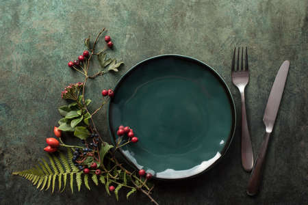 Thanksgiving table setting, autumn table decor with flowers and berries