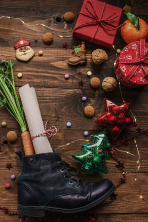 Holiday background Saint Nicholas, Sinterklaas, children's shoe with carrots, cookies, nut, tangerines, gifts and sweetsの写真素材