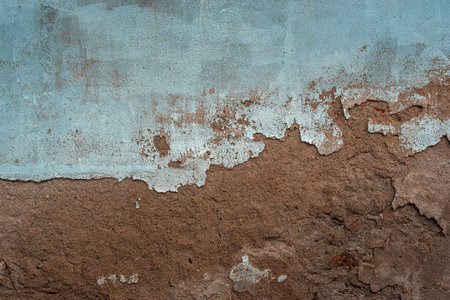 Light blue painted wall with sprinkled clay putty old textured background with drips and cracksの写真素材