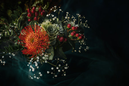 Beautiful autumn flowers and berries on the dark background. Top view with copy space. Autumnal concept.の写真素材
