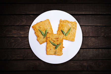 Three tempeh, fried flour with chilies served on a white plate. Top view.の写真素材