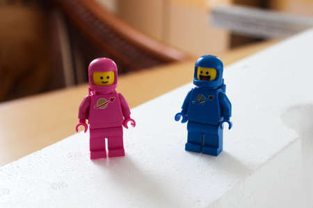 Two blue and pink Lego astronaut on a white styrofoam background.のeditorial素材