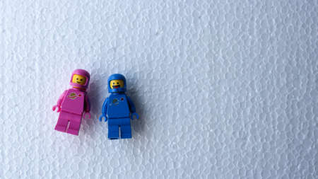 Two blue and pink Lego astronauts lied down with cheerful expressions as they looked up.のeditorial素材