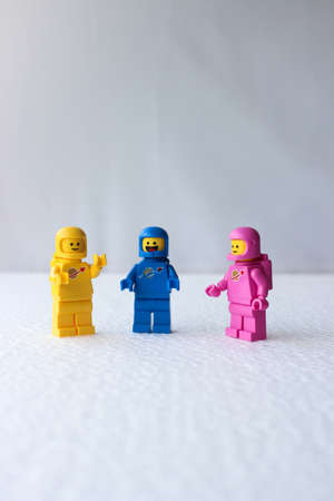Three Lego astronauts having a discussion while standing on a white background.のeditorial素材