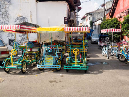 Penang,  Malaysia - June 02, 2016:  Colorful  quadricycles or surrey bikes for rental in the area of...