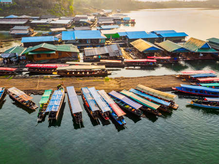 Sangkhlaburi - March 05, 2017: The scenery of  floating village and tourist boats and a part of temporary bamboo bridge  the river in Sangkhlaburi District, Kanchanaburi Province, Thailand, in the early morning.のeditorial素材