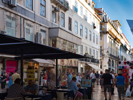 Lisbon, Portugal - October 01, 2019:  People walking and sitting in the outdoor restaurant at Rua Augusta or Augusta street in downtown of Lisbon, Portugal.のeditorial素材