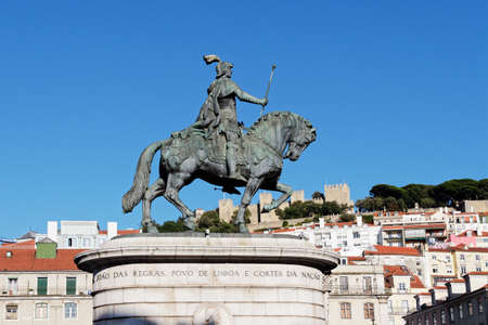 The statue of King Dom Joao or King John 1 in Figueira Plaza, Lisbon, Portugal, with old buildings and blue sky are in the background.の写真素材