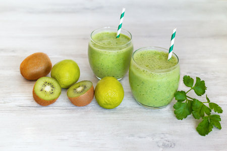 Healthy dieting and nutrition, vegan, vegetarian concept, healthy lifestyle. Green smoothie with organic ingredients, vegetables on a wooden table.の写真素材