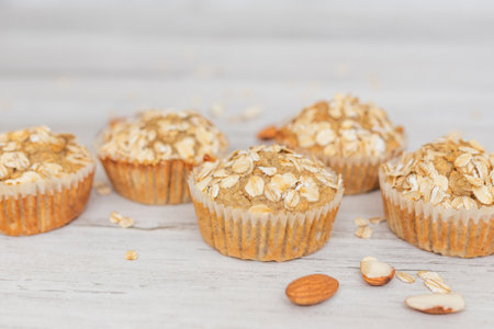 Cereal, oatmeal, banana muffins on white wooden table. Homemade cupcake. A healthy treat.の写真素材
