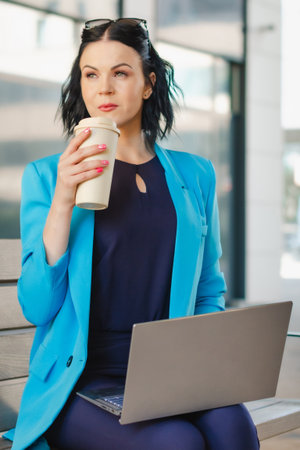 Young business woman leader entrepreneur, professional manager with coffee holding laptop computer...