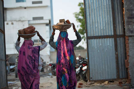 Indian women carrying bricks on their heads at a construction siteのeditorial素材