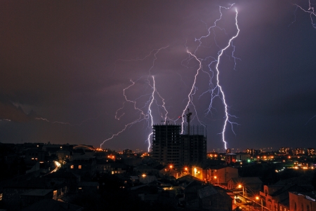 flashes of lightning in the night sky in the cityの写真素材