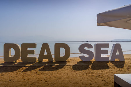 The Dead Sea letters on the coast of Dead Sea at beach resort of Ein Bokek, Israel, during the hot...