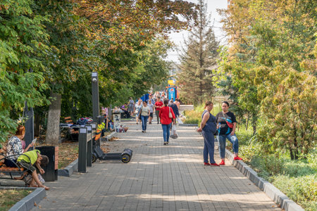 Russian people walking in the city park during the warm sunny day at Belgorod, a city in Russia...