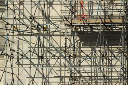 Sunlit Scaffolding with Cast Shadows on the Wall of a Portland Stone Buildingの写真素材