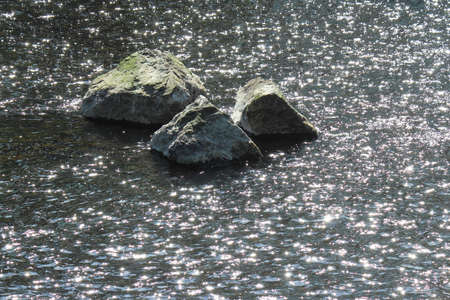 Stones in a River With Sunlight Reflecting on the Rippled Water - River Taff, Cardiff, Walesの写真素材