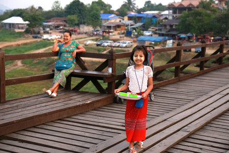 Thailand, Sangkhla Buri District, Kanchanaburi Province : The girl, She sell her make up powder in the evening time at the long wood bridge ,Sell to the tourist on the May 5, 2016  in Kanchanaburi, Thailand.のeditorial素材