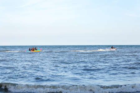 Banana boat in sea. Group of young people riding banana boatの写真素材
