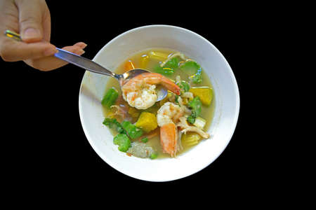 Thai Spicy Mixed Vegetable Soup with Prawns on black backgroundの写真素材