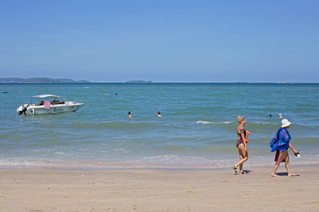Pattaya / Thailand - October 21 2017: Women walk on the beach on the Bright Sky Day with background speedboat and seaのeditorial素材