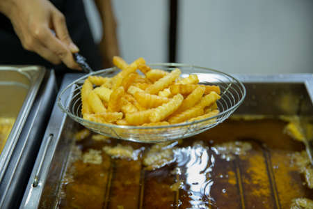Closeup of French fries chips in oil. Unhealthy oily food