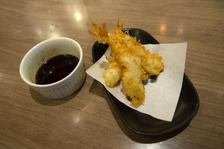 Tempura fried shrimp in black plate on the wood table (Japanese style), in focus selective.の写真素材