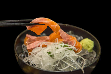 Hamachi Salmon Sashimi with shredded white radish in black backgroundの写真素材