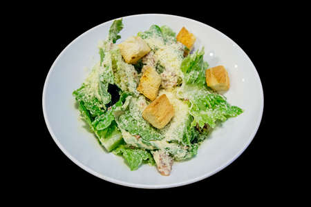 Vegetable salad in white plate, black background isolatedの写真素材