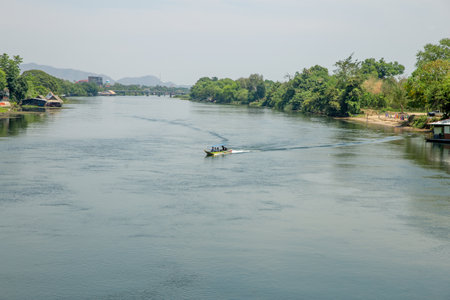 Kanchanaburi, THAILAND - March 29, 2019: People as tourists in the boat river Kwai in the evening on Friday.のeditorial素材
