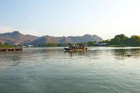 Kanchanaburi, THAILAND - March 29, 2019: Small Local ferry transportation across river transporting people, bicycle and motorcycle Maeklong River,Thailandのeditorial素材