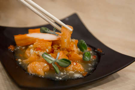 Raw Salmon salad Sashimi on black plate.