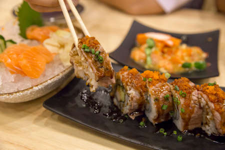 Chopsticks on wagyu beef Original Japan sushi on wood table, focus selective.の写真素材