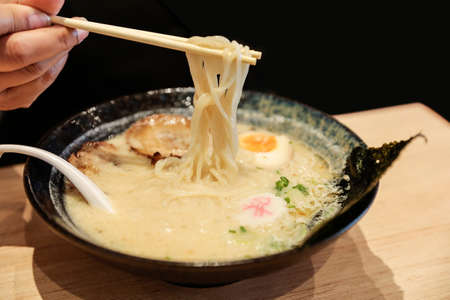 Delicious Japanese tonkatsu ramen with chopsticks in bowl, focus selective.の写真素材