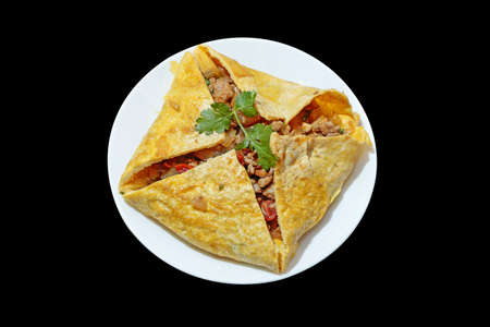 One Stuffed Thai Omelette on white plate on black isolatedの写真素材
