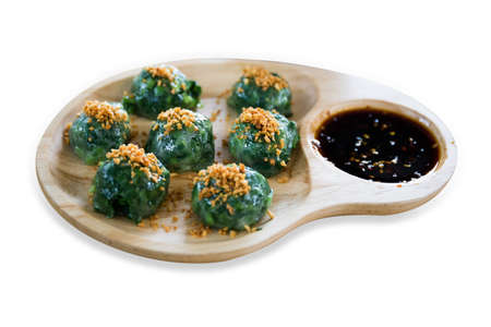 Steamed chives dumplings, the food is made from vegetable, thin flour Served with Sweet Black Soy Sauce on woodern plate and die cut on white isolated, focus selective.の写真素材