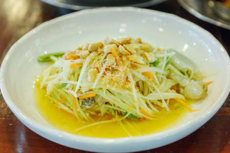 Top view of Thai style spicy papaya Salad (Som tum) with sliced salted egg