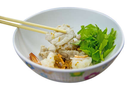 Chopstick with boiled striped bass fish on the white bowl, focus selective.