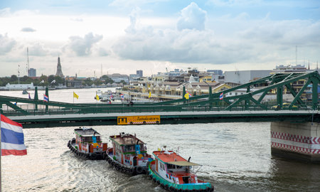 Bangkok / Thailand - July 7 2020: Boat Cargo ships passing under the bridge View from Chao Phraya Sky Park, Chao Phraya River close to Phra Pokklao Bridge in, Thonburi, Bangkok, Thailand.のeditorial素材