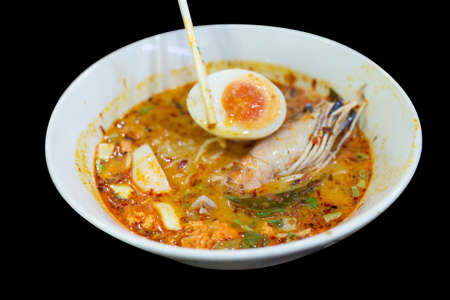 Top view of Tom Yum Goong spicy shrimp soup with Thai spices, focus selective
