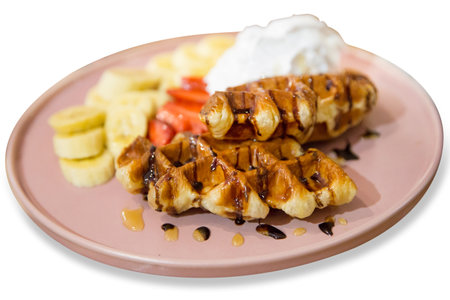 Top view of belgium waffles topping with whipped cream and banana slice, focus selectiveの写真素材