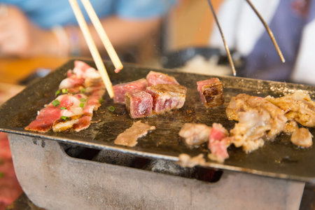 Die cut of dice beef and Striped calf beef on the pan and stove on white isolated.の写真素材