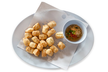 Die cut of fried tofu in dice shape with sweet sauceon white isolated.の写真素材